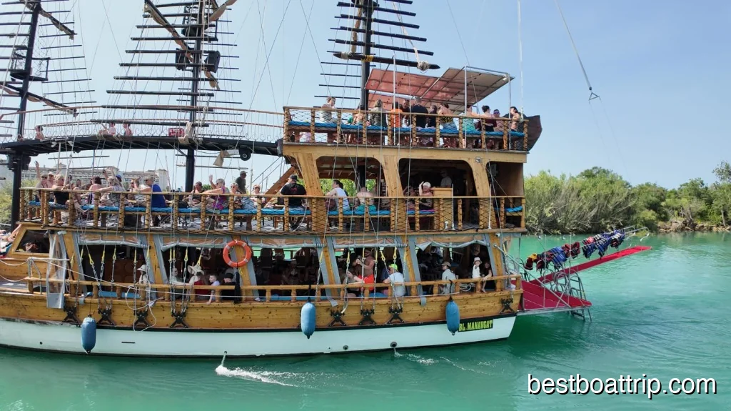 Wooden pirate ship full of passengers cruising on turquoise Manavgat River